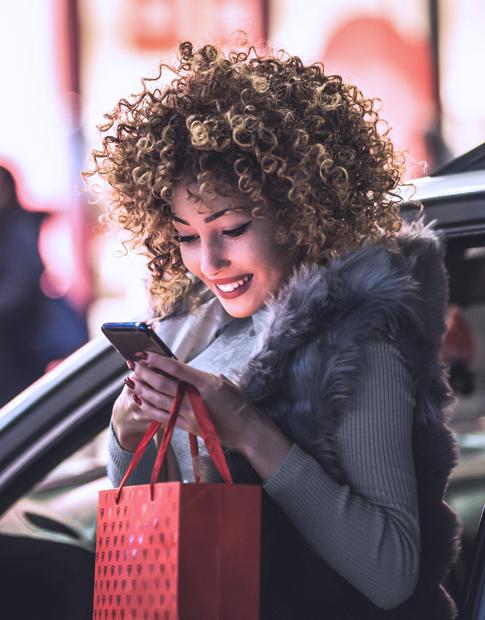 Agero - Woman on smart phone outside her vehicle 