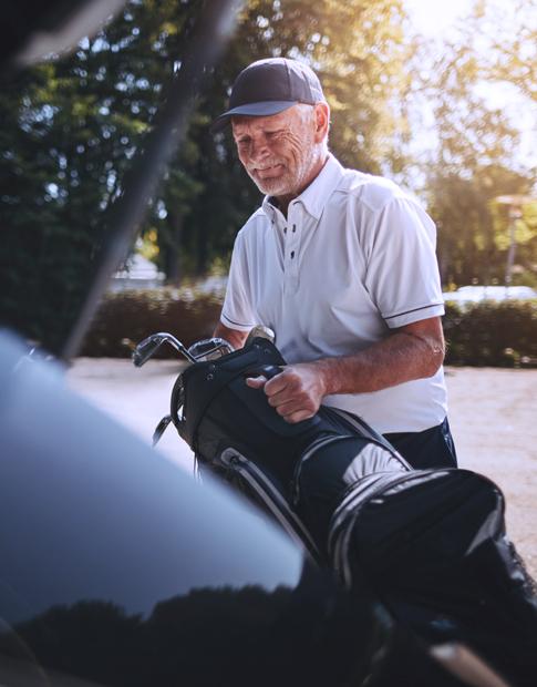 Agero - Golfer unpacking golf bag from vehicle.